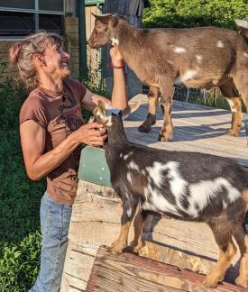 Ellen Petrick on her Wisconsin homestead. She is petting two goats