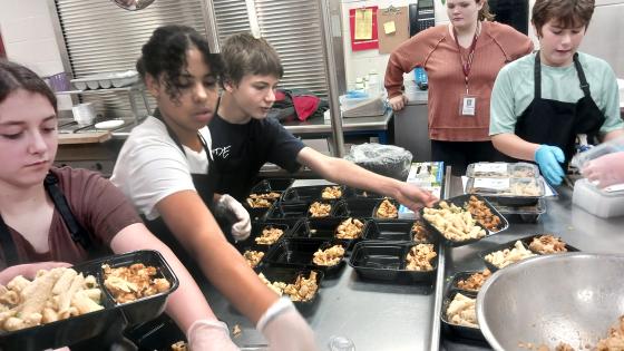 Students at Brighton Elementary package meals for senior residents of Sunrise Manor in Island Pond